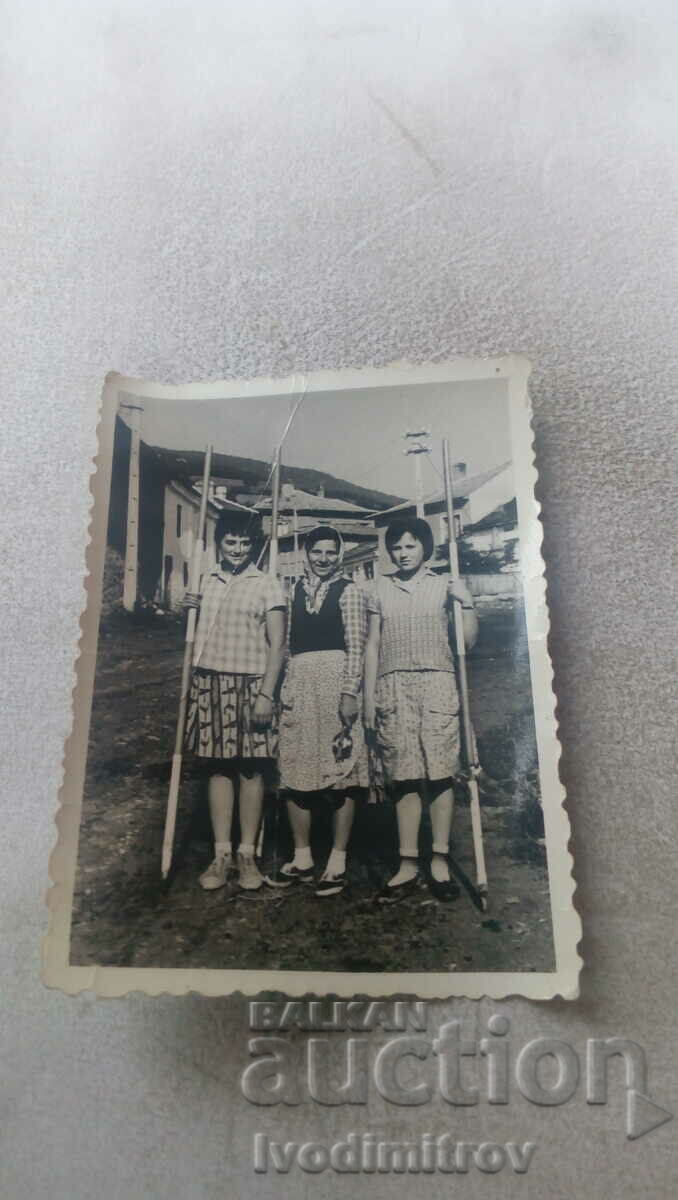 Φωτογραφία Τρεις γυναίκες που κρατούν πυλώνες