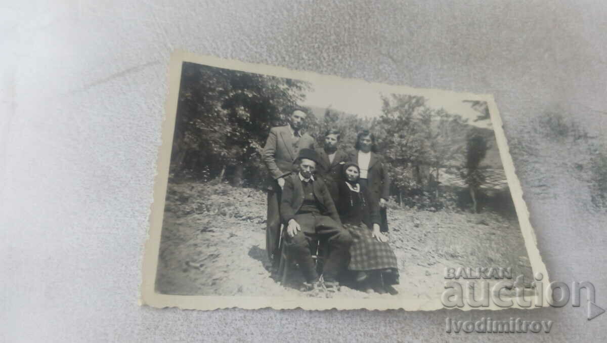 Foto Doi bărbați, două femei și un băiat în grădină