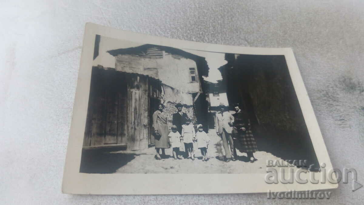 Photo Two men two women and three children on a village street