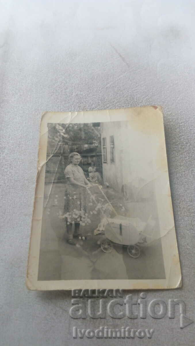 Foto Femeie cu un cărucior pentru copii retro