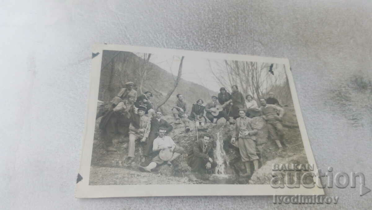 Fotografie Bărbați și femei tinere lângă o mini cascadă