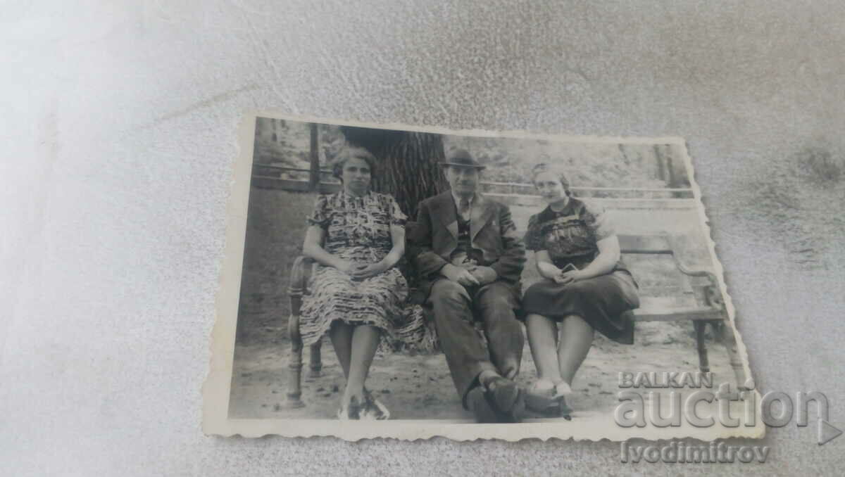 Φωτογραφία Σοφία Ένας άνδρας και δύο γυναίκες σε ένα παγκάκι στον κήπο της πόλης