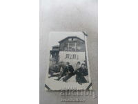 Foto Trei bărbați și o femeie în fața unei cabane de munte iarna