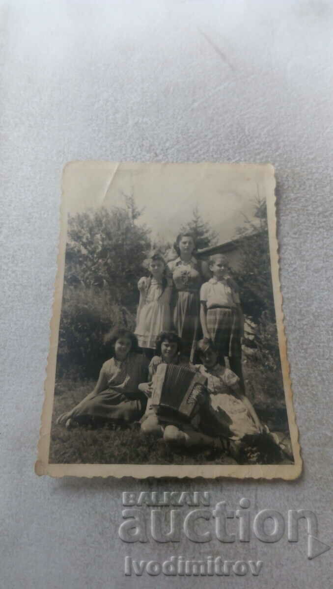 Photo Young girls with an accordion in the yard