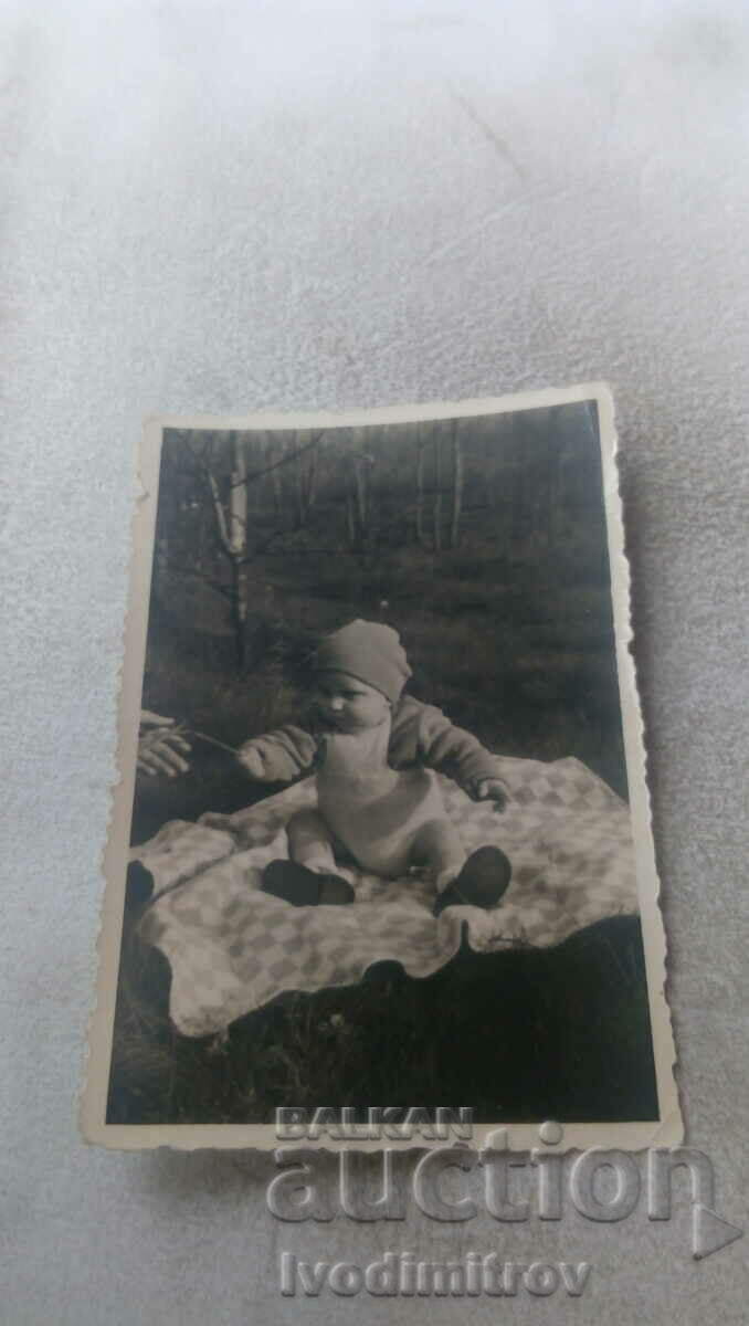 Fotografie Bebeluş pe o pătură pe gazon