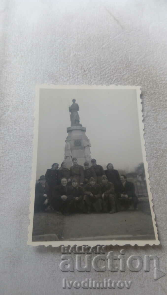 Fotografie Soldați bărbați și femei în fața monumentului unui soldat