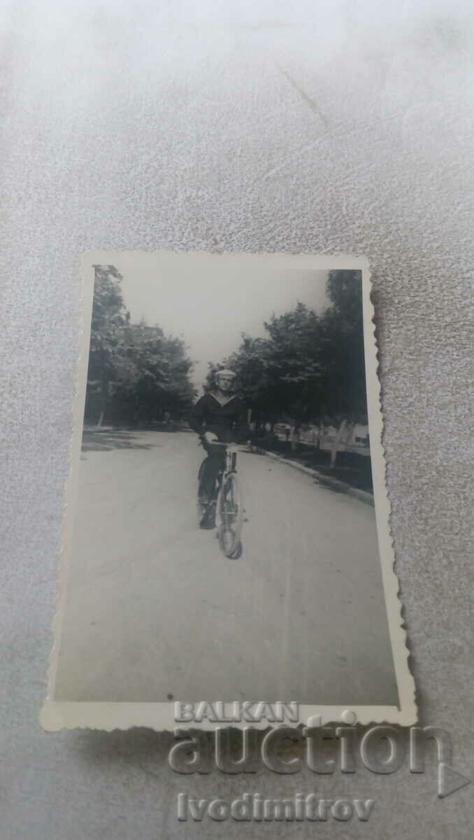 Photo Cadet with a vintage bicycle on the road