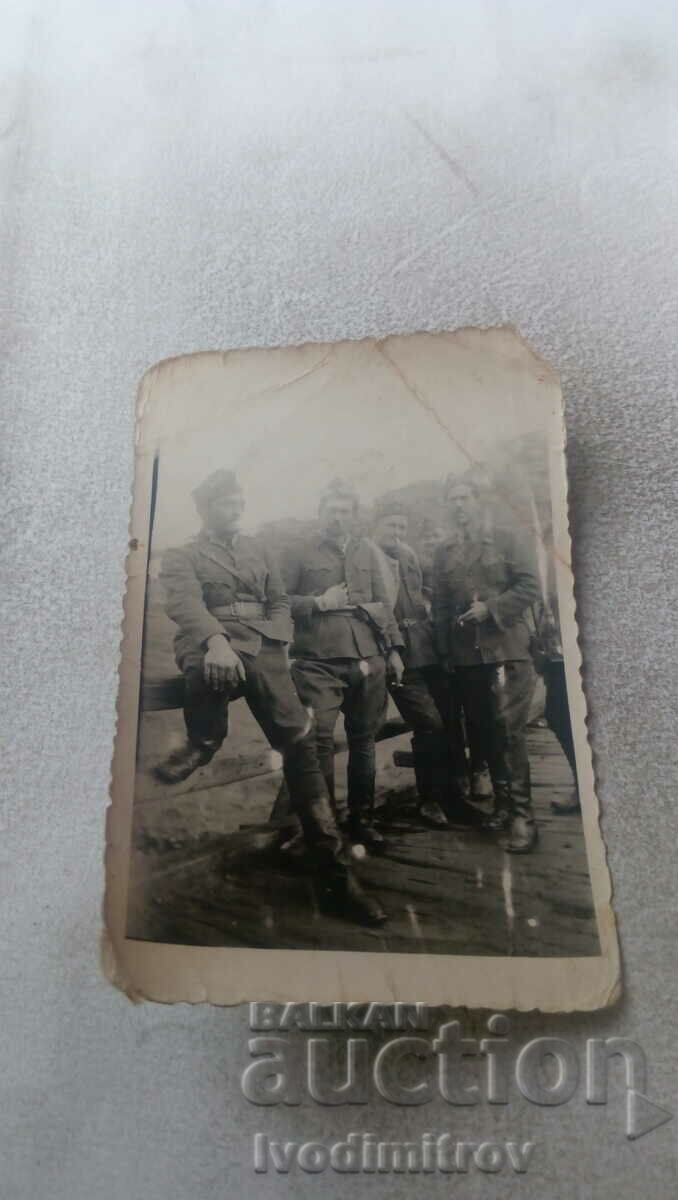 Εικόνα Πέντε στρατιώτες δίπλα σε ένα ξύλινο κιγκλίδωμα