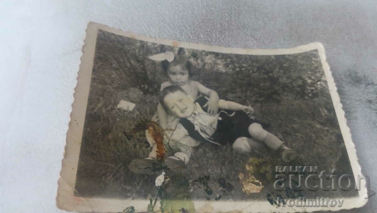 Φωτογραφία Ένα αγοράκι και ένα κοριτσάκι στο γρασίδι