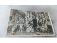 Photo Man women and children on wooden deckchairs in the forest