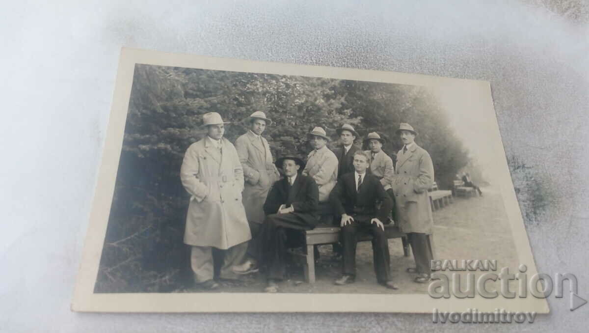 Φωτογραφία Άνδρες με κάπες σε ξύλινο παγκάκι στο πάρκο