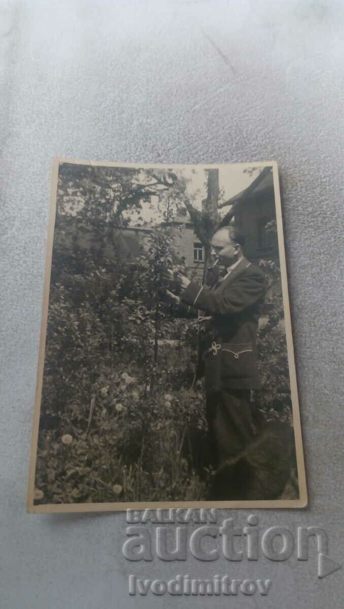 Photo A man with a pipe in the yard of his house