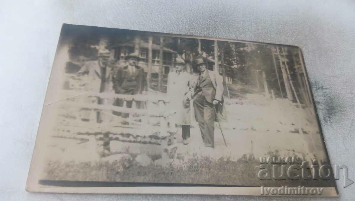Photo Four men in front of a cabin in the forest