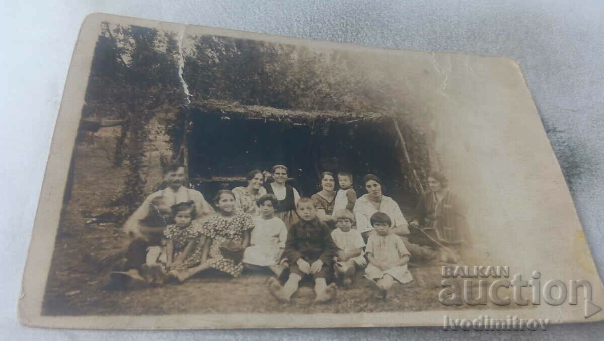 Photo Iskrets Man women and children in front of a wooden shed