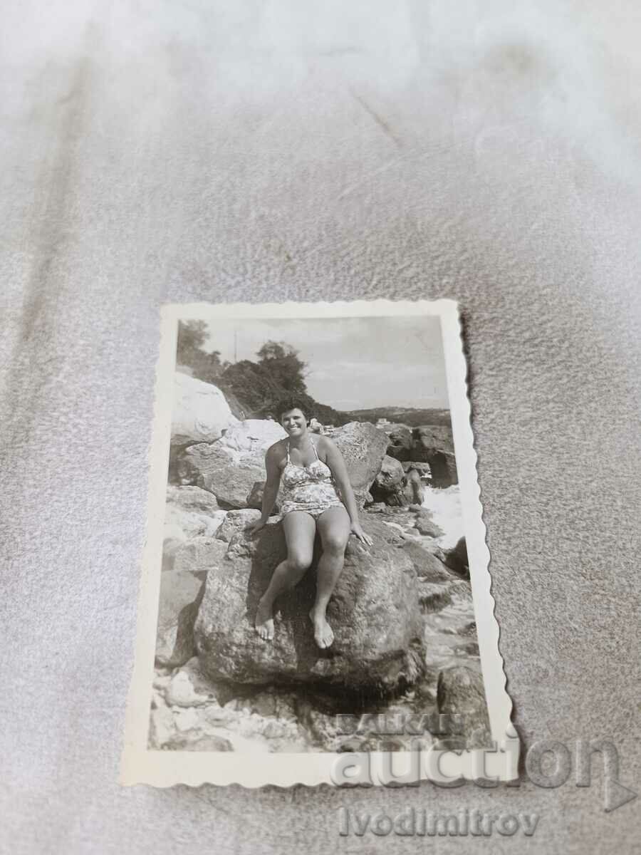 Снимка Жена на голям камък на брега на морето