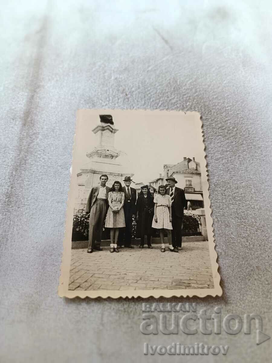 Photo Three men, a woman and two girls in front of a monument