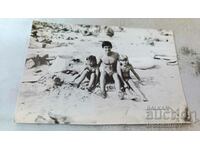 Fotografie Un tânăr și două fetițe pe plajă