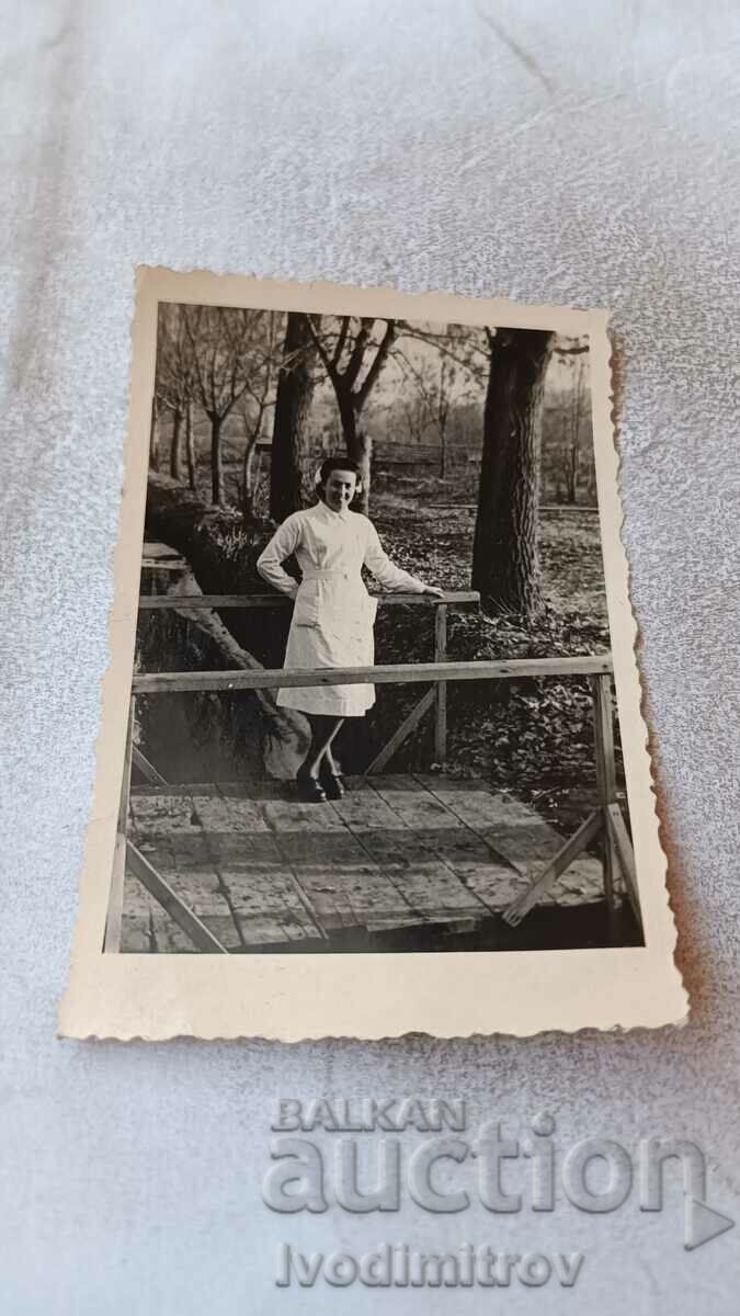 Φωτογραφία Σκοπιανή γυναίκα με λευκή ποδιά σε ξύλινη γέφυρα 1943