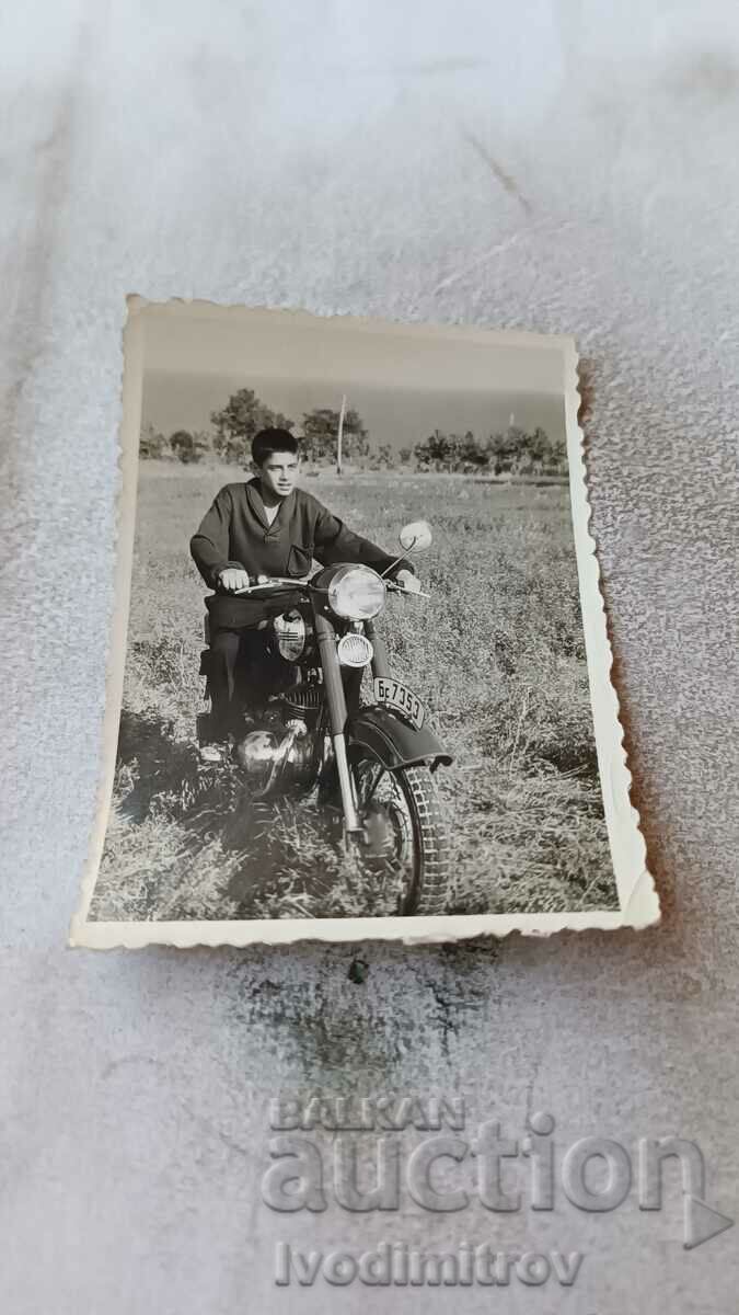 Φωτογραφία ενός αγοριού σε μια vintage μοτοσυκλέτα με αριθμό κυκλοφορίας Bs 7353
