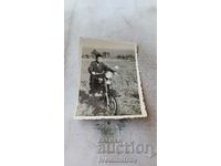 Φωτογραφία ενός αγοριού σε μια vintage μοτοσυκλέτα με αριθμό κυκλοφορίας Bs 7353