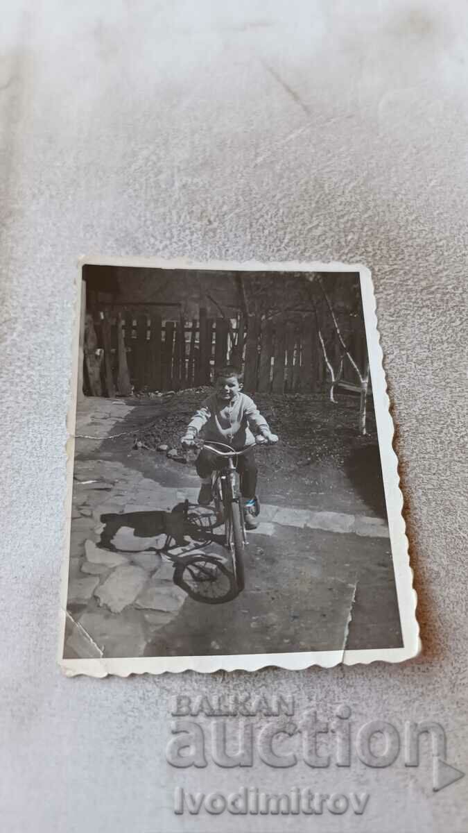 Photo Little boy with a vintage bicycle in the yard