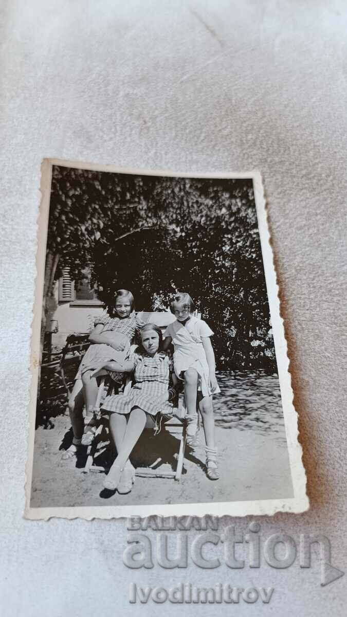 Снимка Горна Баня Три момичета на дървен стол в двора