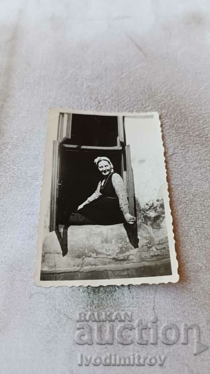 Foto Femeie la fereastra unei case vechi