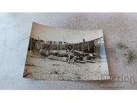 Photo Woman sitting on a pile of wood in the yard