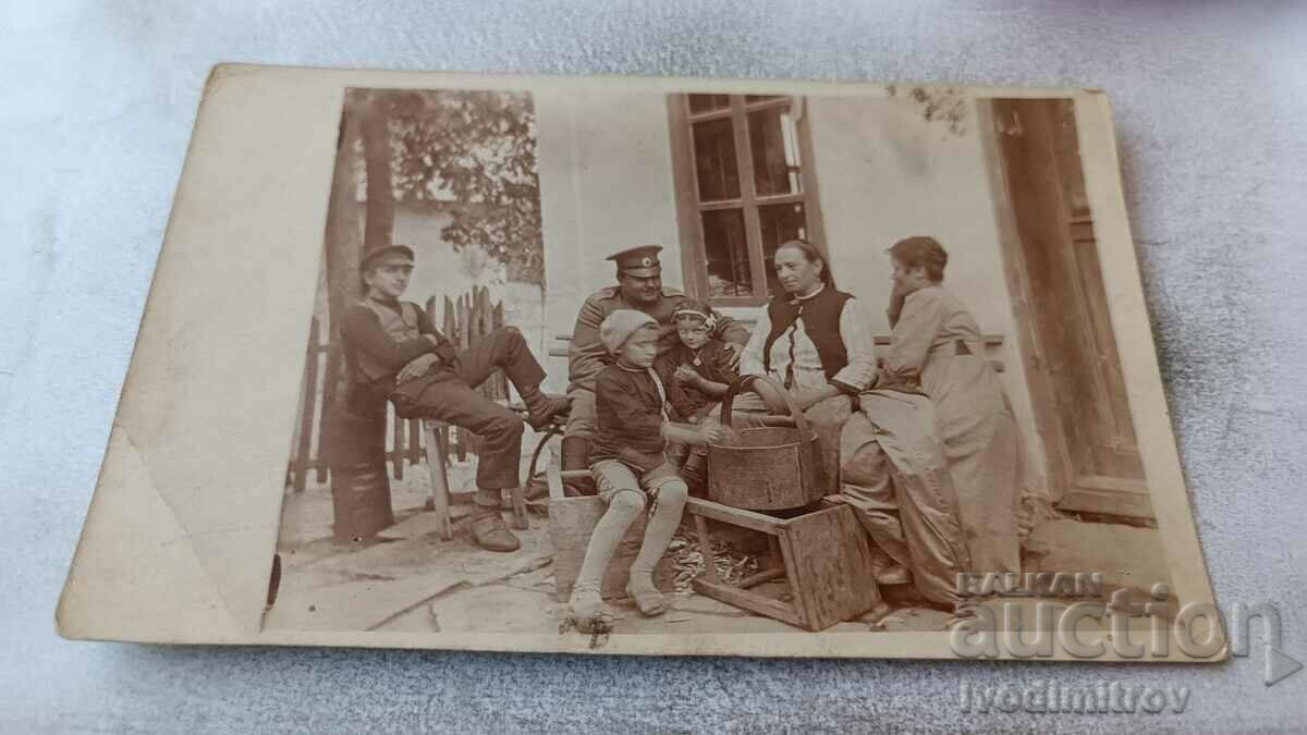 Ofițer foto femei și copii în curtea casei sale