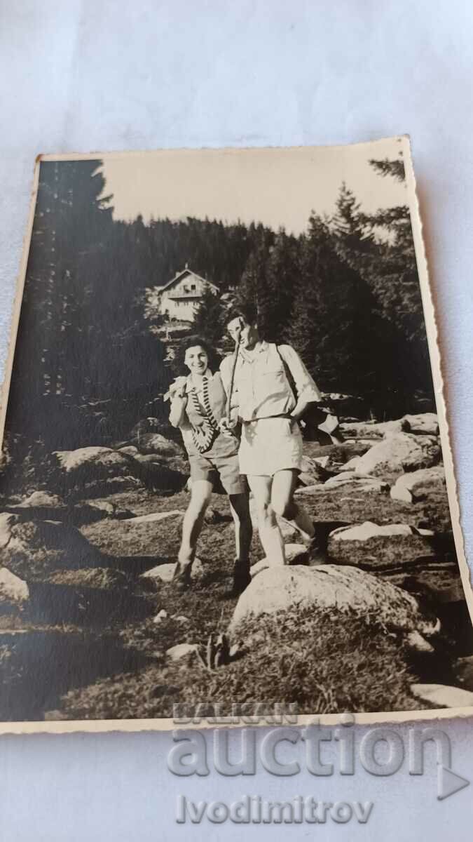 Photo A man and a young woman in a stream in the mountains