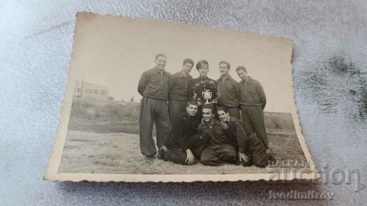 Photo Officer and young men in tracksuits with a cup