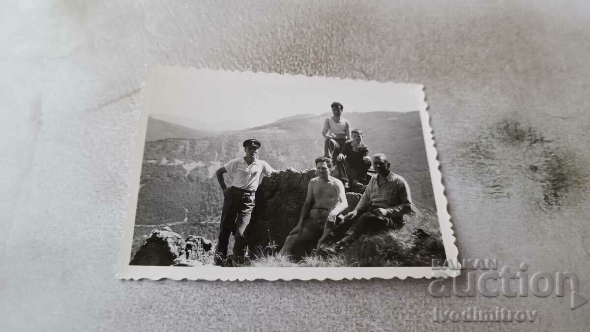 Photo Four men and a boy on a rock in the plain