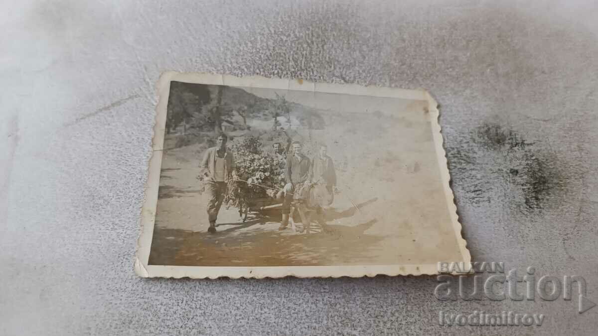 Φωτογραφία Τέσσερις άντρες με ένα ξύλινο καροτσάκι γαϊδουριού