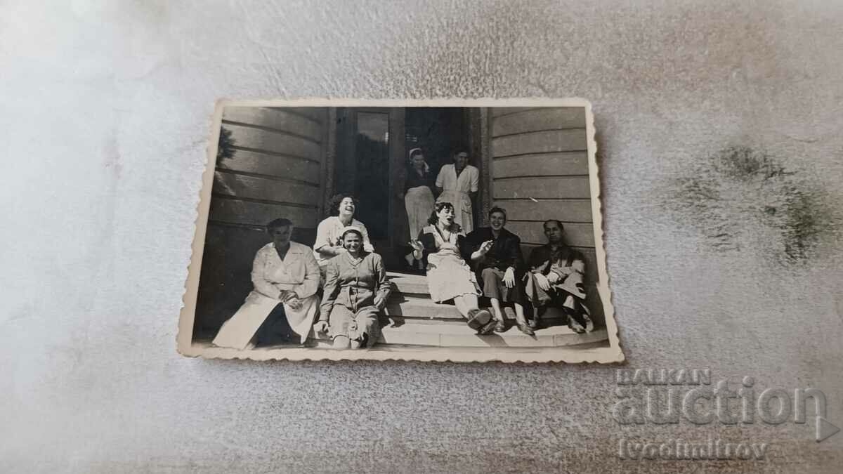 Photo Man and women sitting on stairs