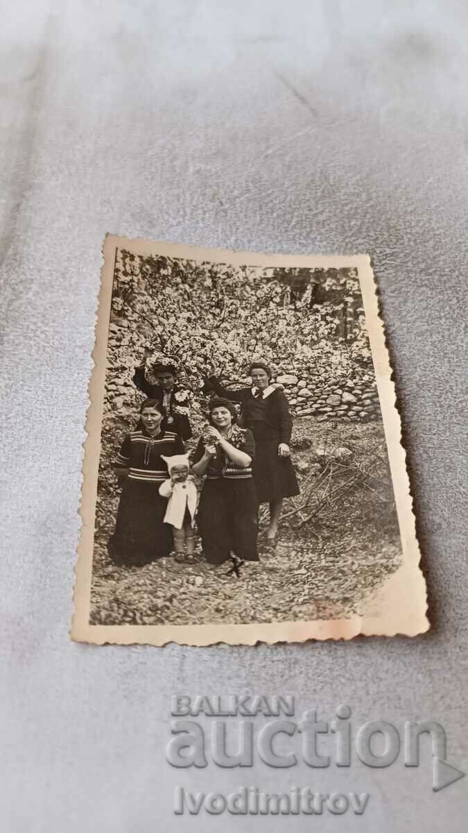 Doamna Lovech Patru tinere și o fetiță într-o grădină înflorită