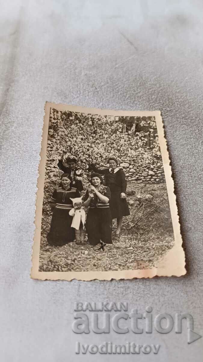 Mrs. Lovech Four young women and a little girl in a blossoming garden