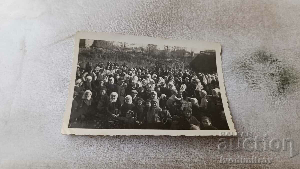 Снимка Мъже и жени с бели забрадки на площада на селото