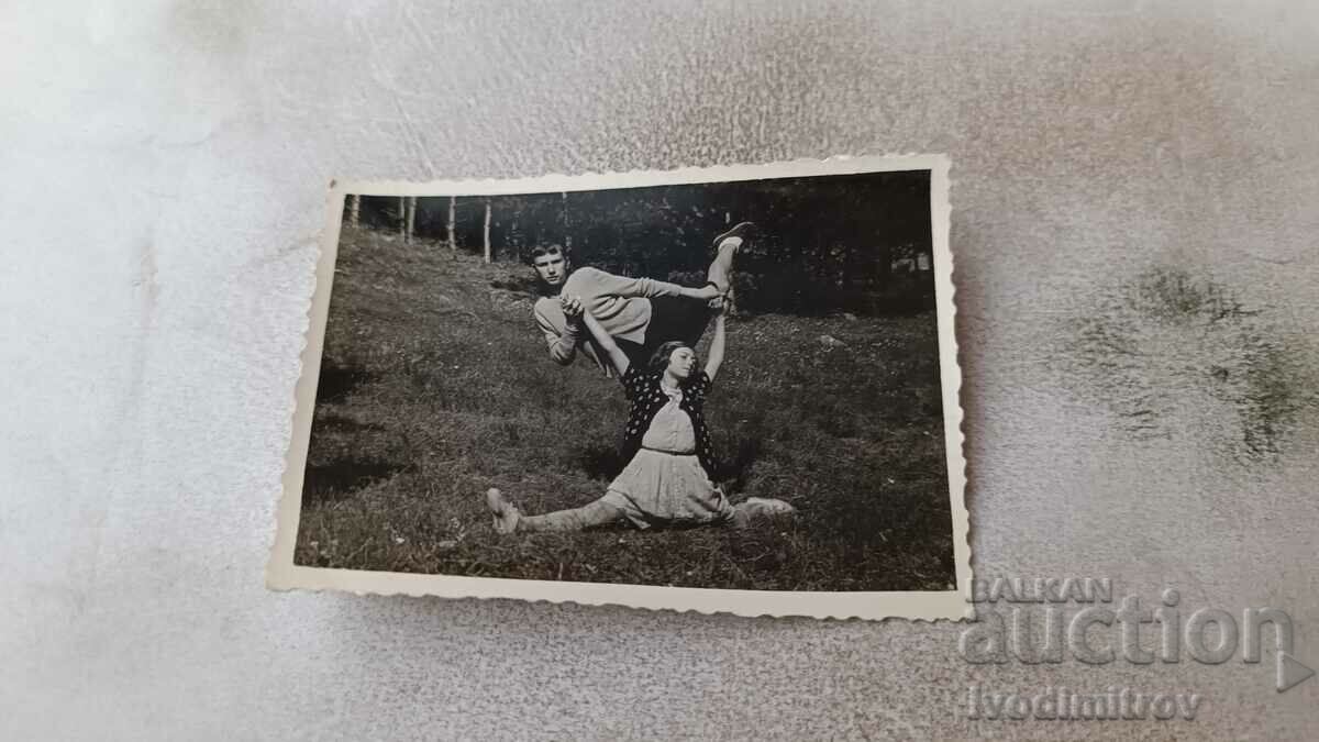 Φωτογραφία Ένα αγόρι και ένα κορίτσι με έναν κουμπαρά στο λιβάδι