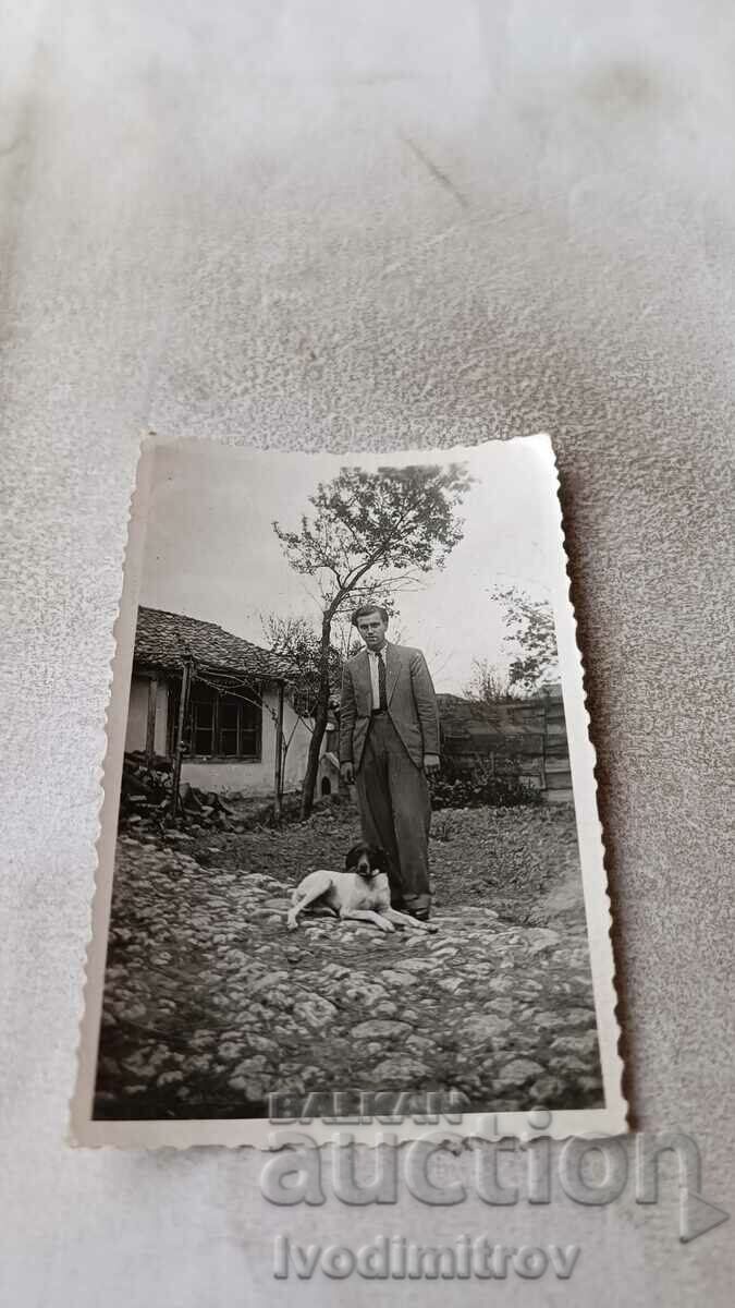 Fotografie Un bărbat și un câine în curtea unei case vechi de țară