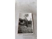 Photo A man and a dog in the yard of an old country house