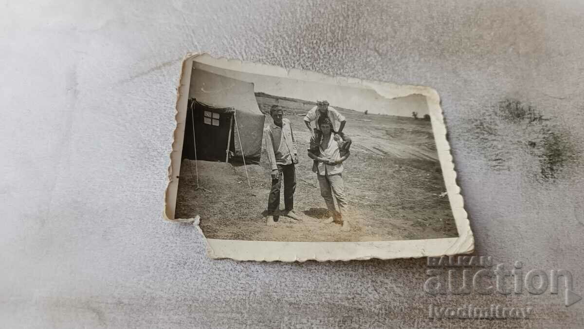Foto sat Trei băieți desculți în fața unui cort