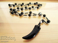 Rosary type necklace of natural Hematite with acrylic horn, tooth