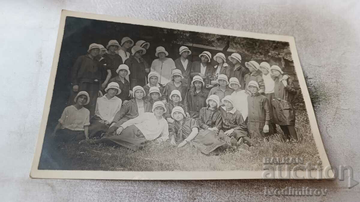 Photo Young girls with white hats on a meadow in the park