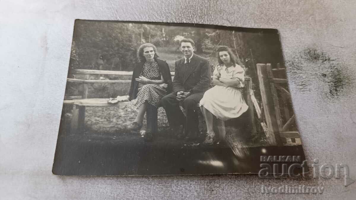 Fotografie Bărbat femeie și fată tânără pe o bancă de lemn 1942