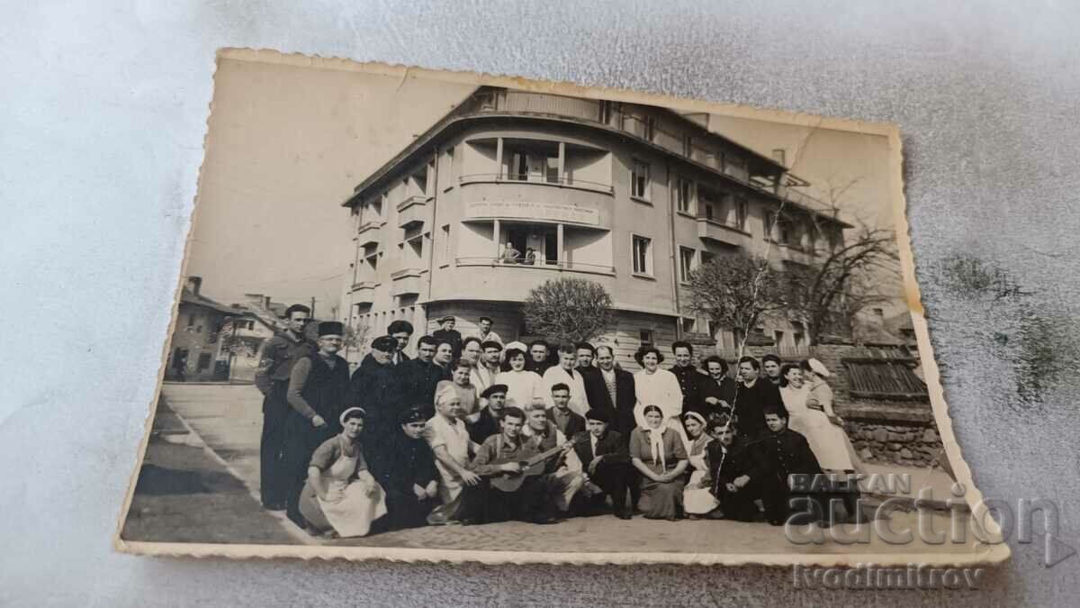 Photo Newlyweds with their friends in front of a building on the street