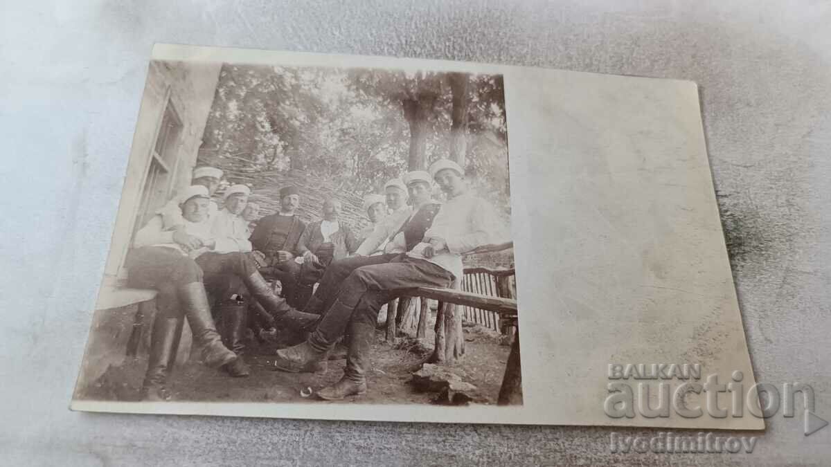 Photo Officers and two men in front of a cabin in the woods