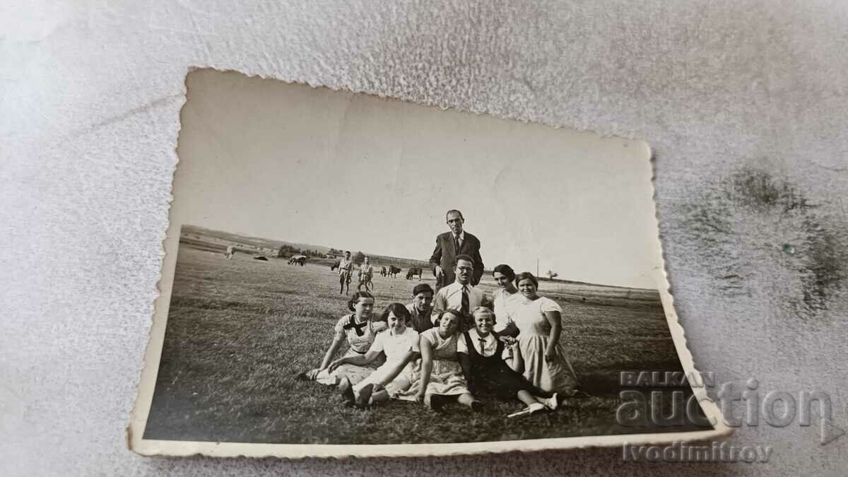 Photo Three men and young women on the meadow