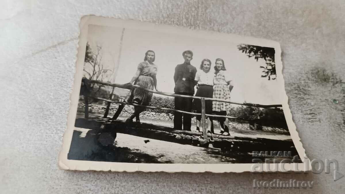 Φωτογραφία Ένας μαθητής και τρία νεαρά κορίτσια σε μια ξύλινη γέφυρα