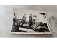 Fotografie Un student și trei fete tinere pe un pod de lemn