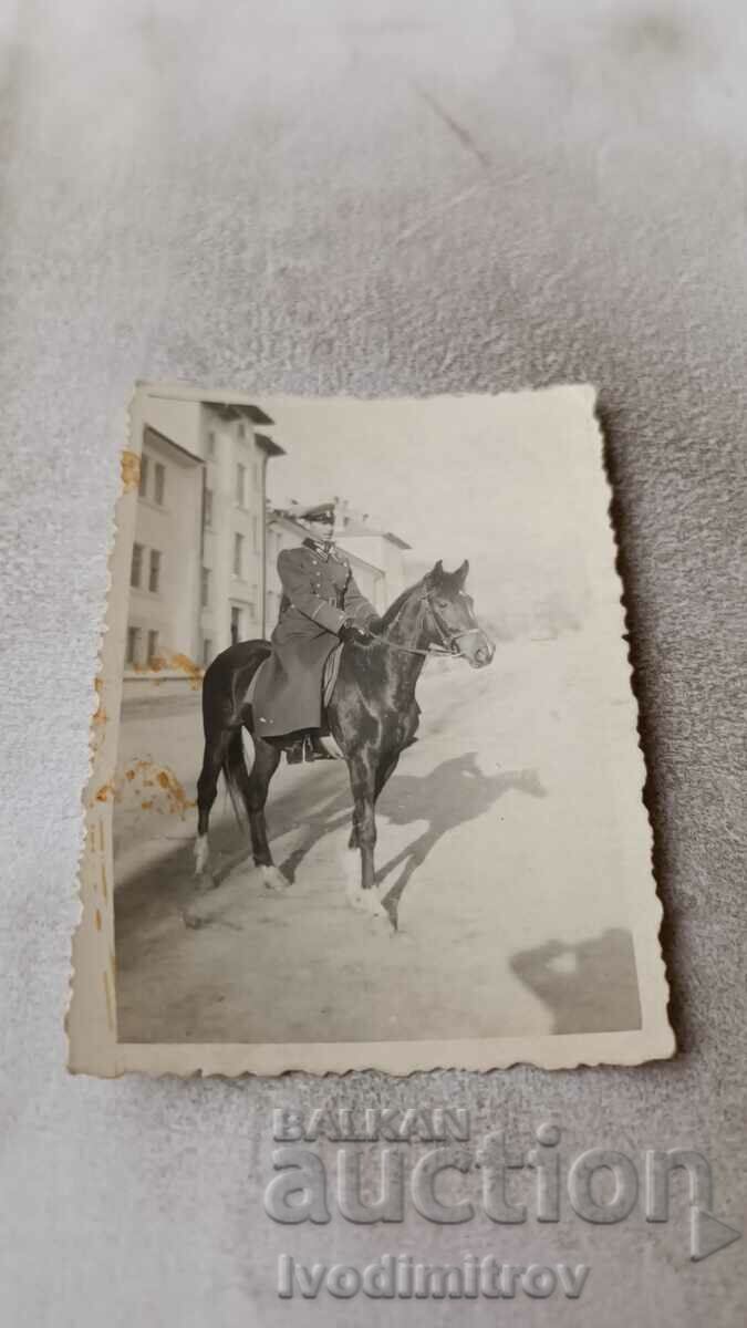 Αξιωματικός φωτογραφιών σε ένα μαύρο άλογο στο δρόμο